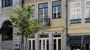 A multi-story building with a mix of architectural styles, including a classical facade and a modern balcony. - NorteSoul Mouzinho (Porto)