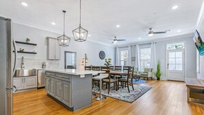 A spacious kitchen with a central island, wooden flooring, and modern appliances.