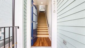 Un escalier menant à un deuxième étage, avec une porte bleue en bas.