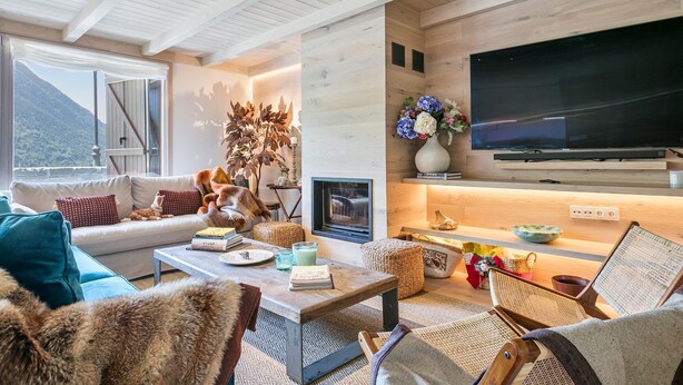 Una sala de estar acogedora con chimenea, un televisor de pantalla plana grande y una zona de estar cómoda.