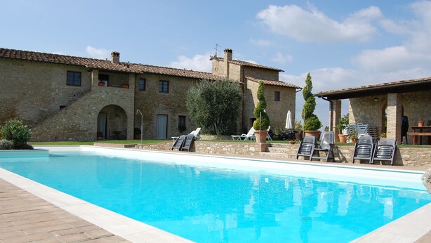 A swimming pool with lounge chairs and a stone building with arches in the background. - Linearis holiday house apt E  (Barberino Val D Elsa (Firenze))
