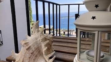 Ein Balkon mit einer großen Muscheldekoration und einer weißen Laterne.