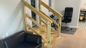 A room with a wooden staircase, a black leather couch, and a black office chair. - Camp Coastal Escape with perks and discounts!! (Jacksonville)