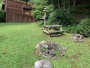 A wooden deck with a lattice design, a picnic table, and a bird feeder.
