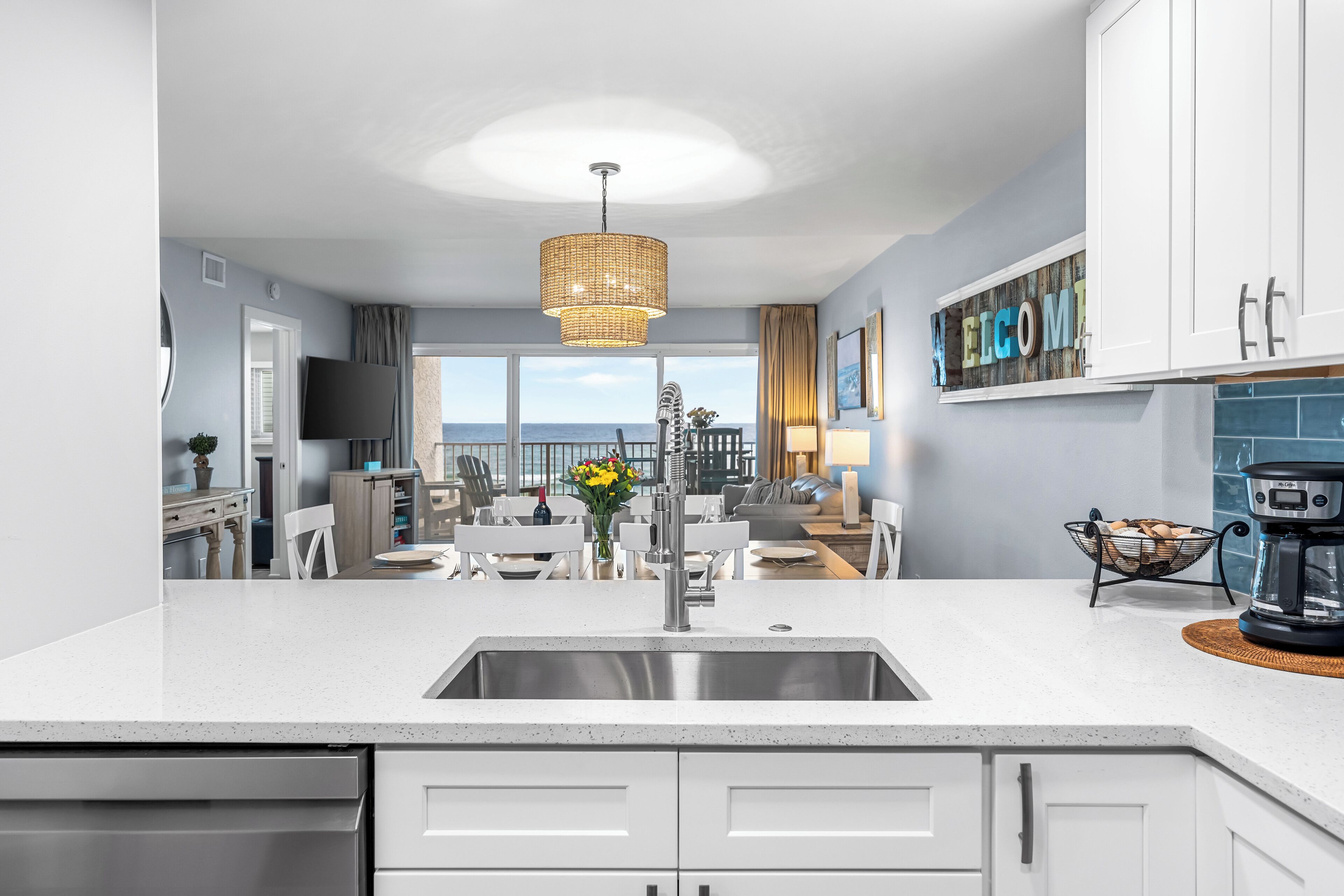 A modern kitchen with a large island, a built-in sink, and a view to the outside.