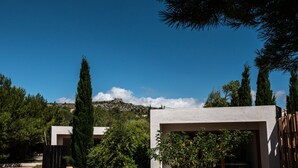 A modern building with a concrete facade, surrounded by lush greenery and tall trees. - 4u Bed & Spa (Opoul-Perillos)