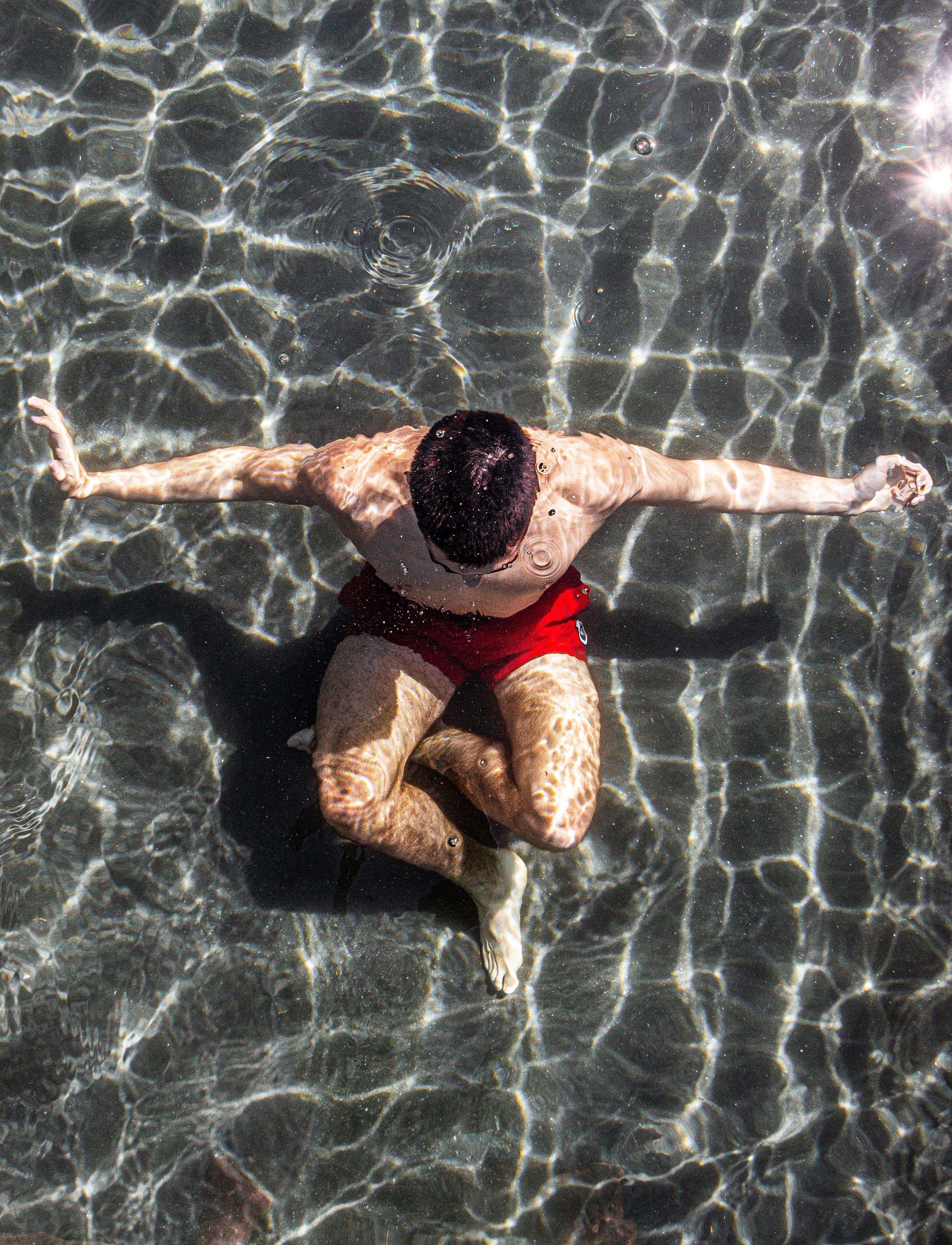 A person floating on water with arms outstretched.