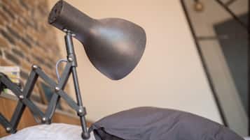 A modern lamp on a desk with a geometric metal frame and a black lampshade.