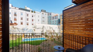 A balcony with a pool, a chair, and a table. - Mercure Porto Centro Aliados (Porto)