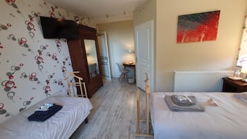 A hotel room with two beds, a TV, a painting, and a desk with a chair.
