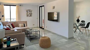 A modern living room with a sofa, coffee table, and a television mounted on the wall.