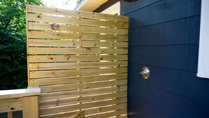 A wooden fence with a metal gate and a wall with a window. - Pecan Paradise: near Beach & Downtown! (Wilmington)