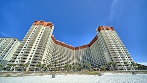 A high-rise hotel with a curved facade, multiple balconies, and a beach view. - Deluxe Beachfront  Studio,  Great Views, "Shores of Panama", Remodeled,  A/C (Panama City Beach)