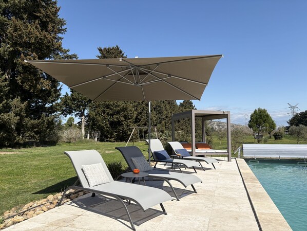 A poolside area with lounge chairs and a large umbrella. - Mas D'auseu (Plan-d'Orgon)