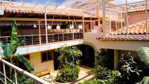 Un vaste atrium doté d’un toit en verre, de nombreux balcons et d’une végétation luxuriante.