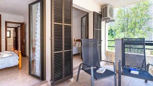 A room with a bed, a chair, and a balcony with a view of trees. - M0 Large apartment of 100 m2 + terraces (Sant Jordi)
