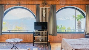 A room with a wooden ceiling, two large arched windows, a television, a small table, and a bed. - Wonderful private villa for 2 guests with TV, patio and pets allowed (Belmonte)