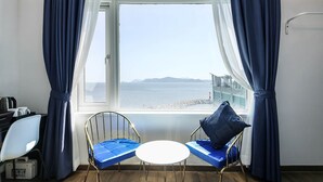 A room with a view of the sea, a small table, two chairs, and a desk with a kettle. - Hotel HYGGELIG - Hostel (Busan)