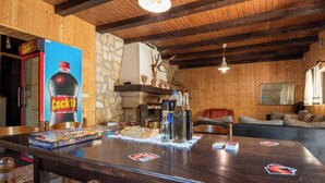 Un interior de madera con una zona de bar, pared de piedra y chimenea.