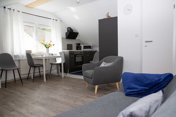A compact living space with a kitchenette, a dining area, and a seating area.