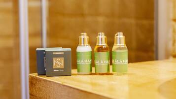 Una encimera de baño con una botella de jabón y tres envases de productos para el cabello.
