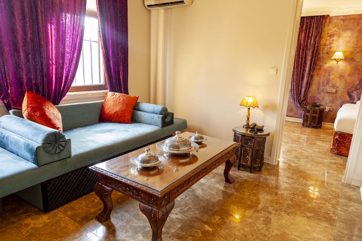 A living room with a sofa, a wooden coffee table, and a lamp.