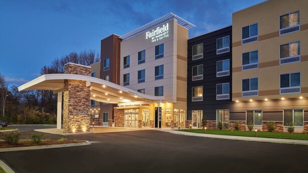 A Fairfield by Marriott hotel with a modern design, featuring a stone facade, multiple floors, and a well-lit entrance.