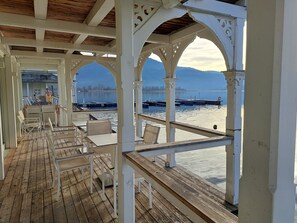 Guests can enjoy the serene waterfront view from this outdoor seating area with a wooden deck and comfortable seating.