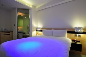 A hotel room with a large bed, bedside tables, a mirror, and a small desk with a kettle. - Hotel 20 Alley (New Taipei City)