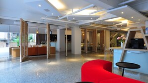 A modern interior with a reception desk, seating areas, and a kitchen. - Hotel 20 Alley (New Taipei City)