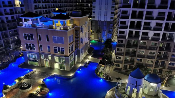 A modern hotel with a rooftop pool, a central courtyard, and a small pavilion. - Arcadia beach condo by Jiabo (Pattaya)