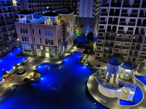 A modern hotel with a rooftop pool, a central courtyard, and a small pavilion.