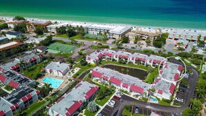 A resort with multiple buildings, a swimming pool, and a beach.