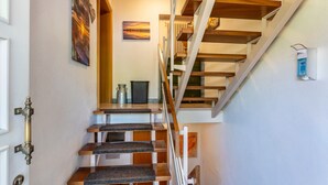 A staircase with wooden steps and a white railing, leading to an upper floor. - Cozy Holiday Apartment "Sonnenuntergang" on Lake Constance with Lake View & Wi-Fi (Gaienhofen)