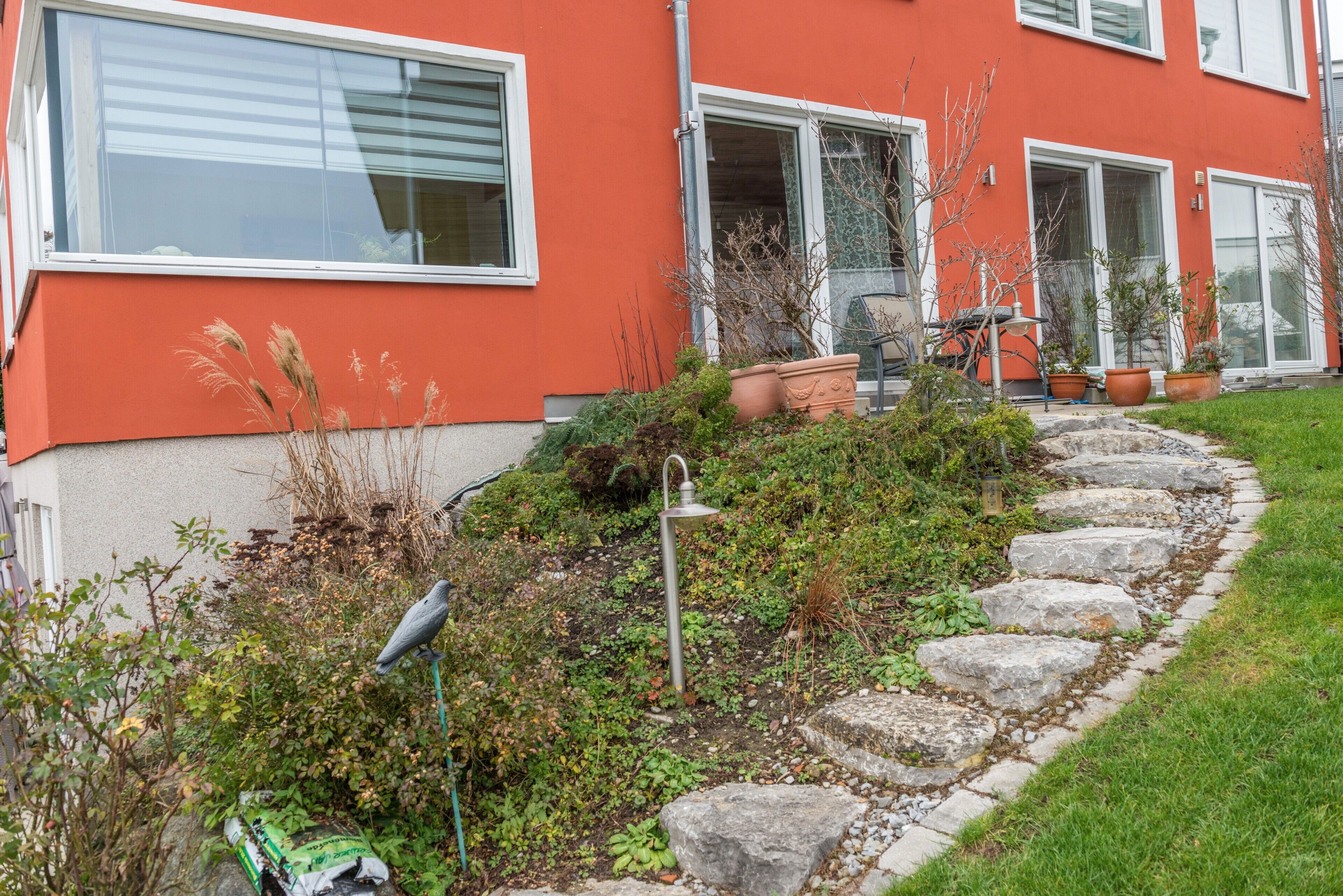 A red building with a garden pathway leading to a door.