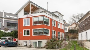 Ein zweistöckiges Gebäude mit roter Fassade und dem Namen 'Caroline' im oberen Bereich.