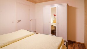 Ein Schlafzimmer mit zwei Betten, einem Kleiderschrank und einer Heizung.