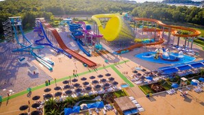 A water park with multiple slides and pools, surrounded by beach areas and umbrellas. - Apartment Andrea (Poreč)