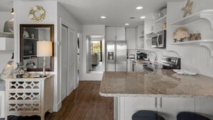 A modern kitchen with white cabinetry, a granite countertop, and stainless steel appliances. - Sleeps 6 @ Beachwood Villas 2 Pools, Mins to Beach + Free Attraction Tickets! (Santa Rosa Beach)