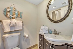 A bathroom with a toilet, a sink, a mirror, and a towel rack. - GORGEOUS DIRECT OCEANFRONT CONDO MYRTLE BEACH - PET FRIENDLY GREAT VIEWS !! (Myrtle Beach)