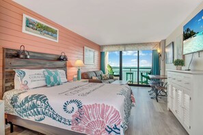 A bedroom with a large bed, a desk, and a balcony with a view of the ocean. - GORGEOUS DIRECT OCEANFRONT CONDO MYRTLE BEACH - PET FRIENDLY GREAT VIEWS !! (Myrtle Beach)