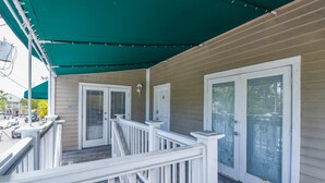 A covered porch with white railings, a green canopy, and a wooden deck. - Parking & Shared Pool - Casa Key West (Key West)