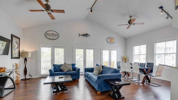 A spacious living area with two sofas, a coffee table, a dining table, and ceiling fans. - Parking & Shared Pool - Casa Key West (Key West)