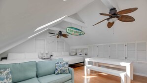 A bedroom with a bed, a sofa, a desk, and a ceiling fan. - Traveler's Palm - Studio Near Duval Street (Key West)