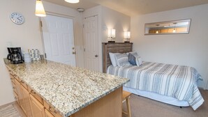 A compact bedroom with a bed, a small kitchenette, and a bathroom. - Tyra Lookout Condo: Ski-In/Ski-Out (Breckenridge)