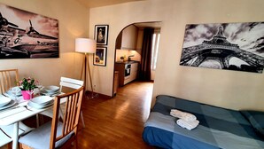 Un espace de vie compact comprenant un coin repas, une kitchenette et un lit.