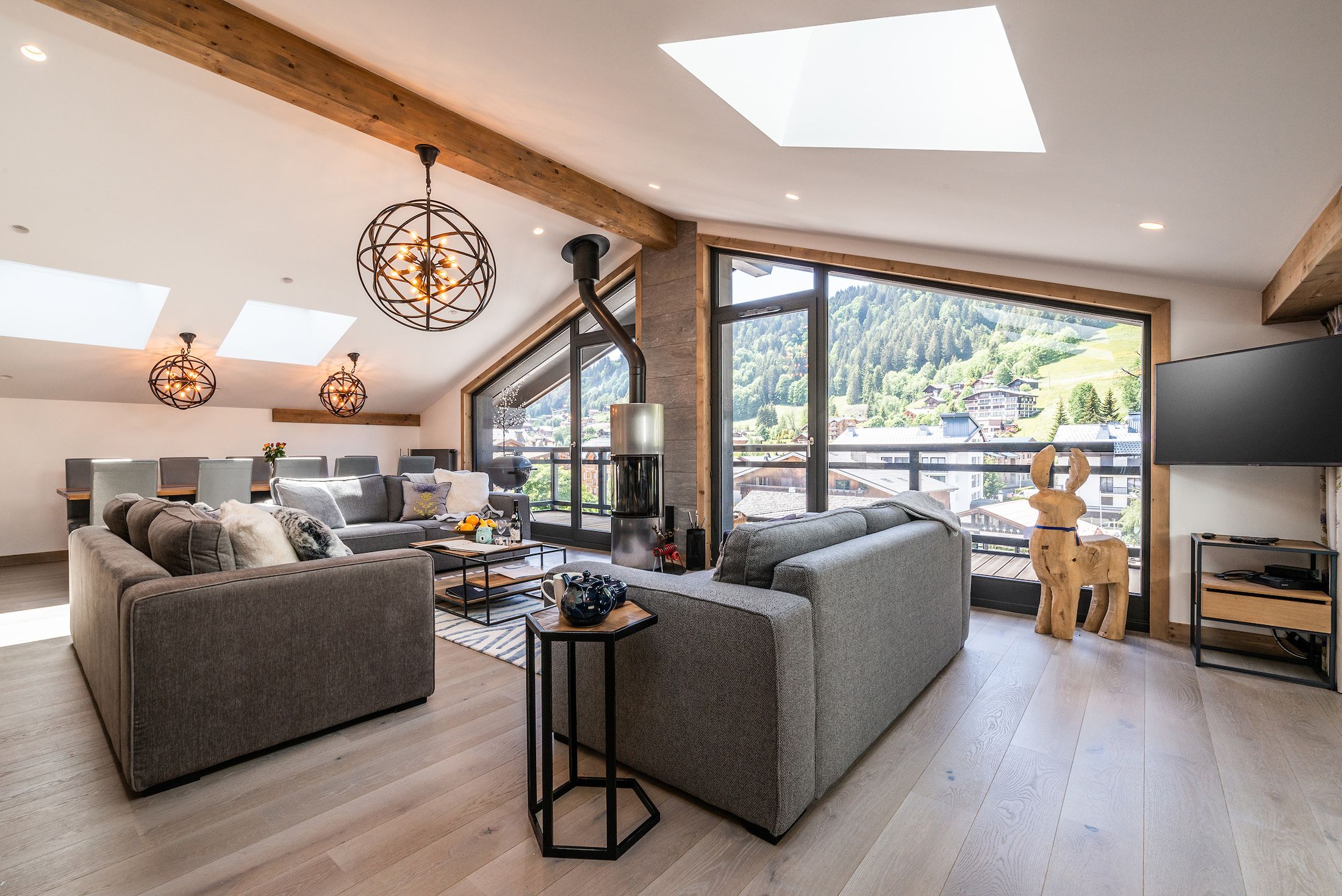 A spacious living area with a large window, a fireplace, and a television.