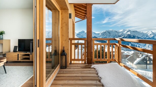 A wooden balcony with a view of snow-covered mountains. - FAGUS - Spacious Apartment in Luxury Residence (Huez)