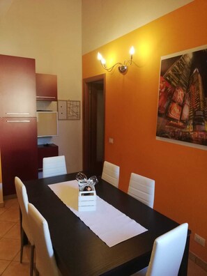 Enjoy meals in this dining area with a table for four, a decorative centerpiece, and a cityscape artwork.
