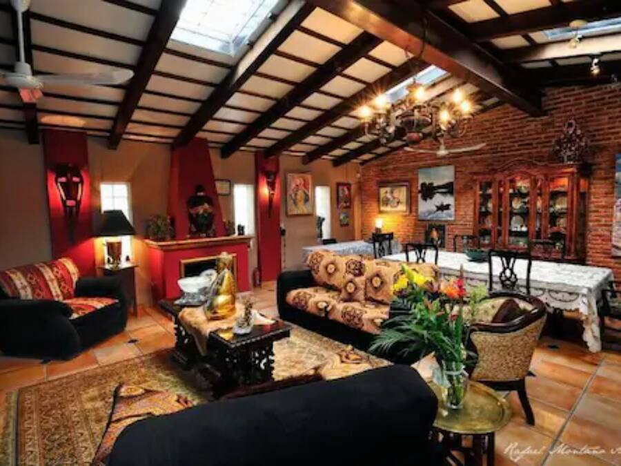 Una sala de estar acogedora con chimenea, asientos cómodos y un comedor con mesa y sillas.